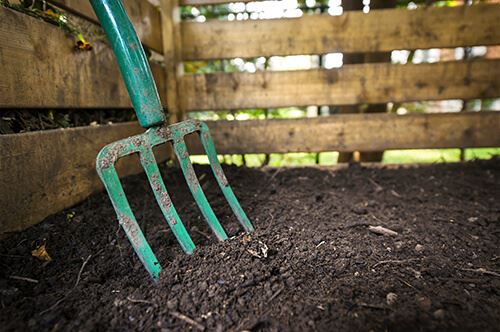 kaw valley start composting turning soil in composter.jpg